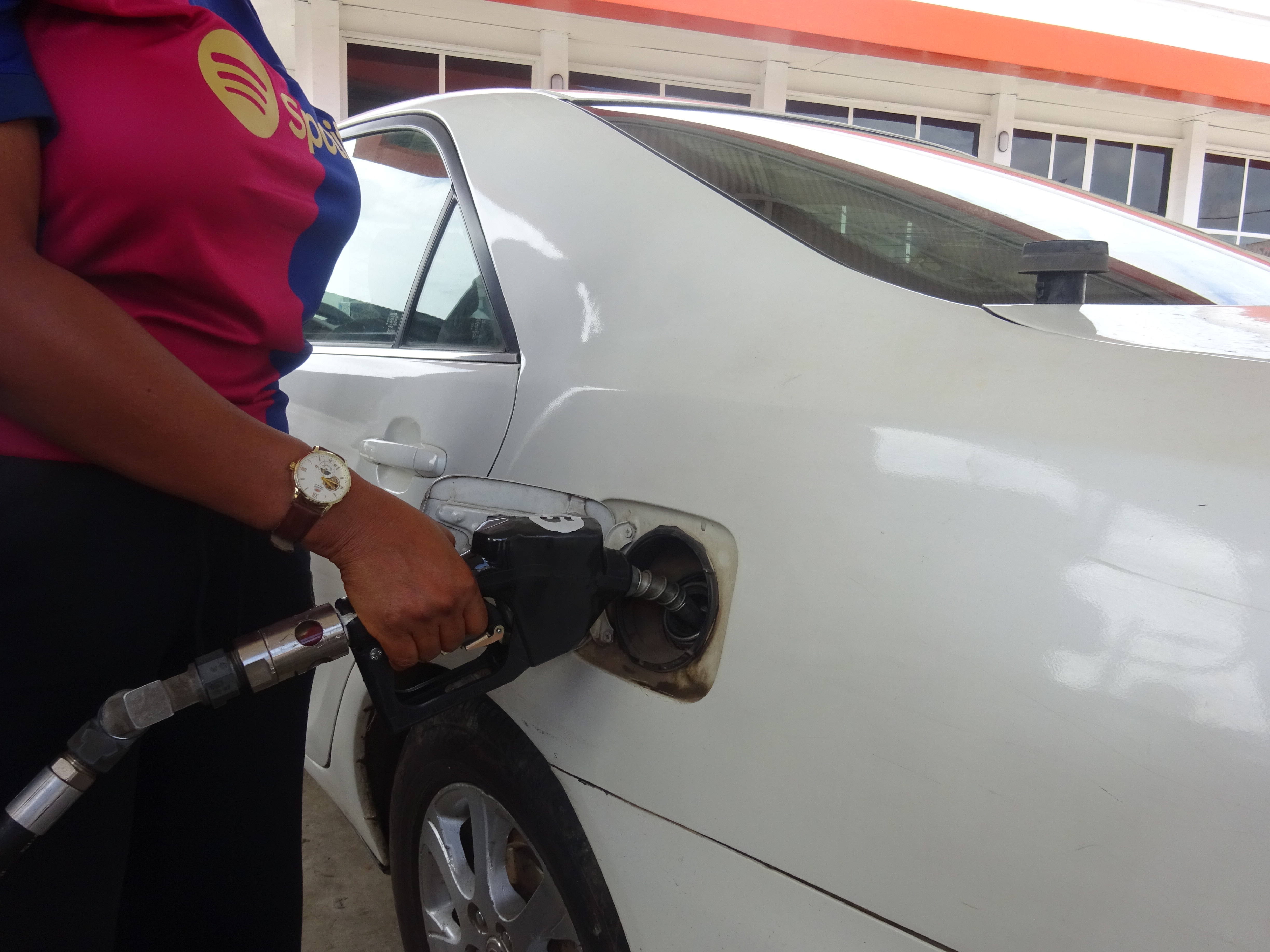Customer fuelling a car at a Sunbeth Energies station with a self-service pump nozzle